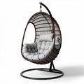 Hanging egg chair with padded cushion in brown rattan for indoor and outdoor use